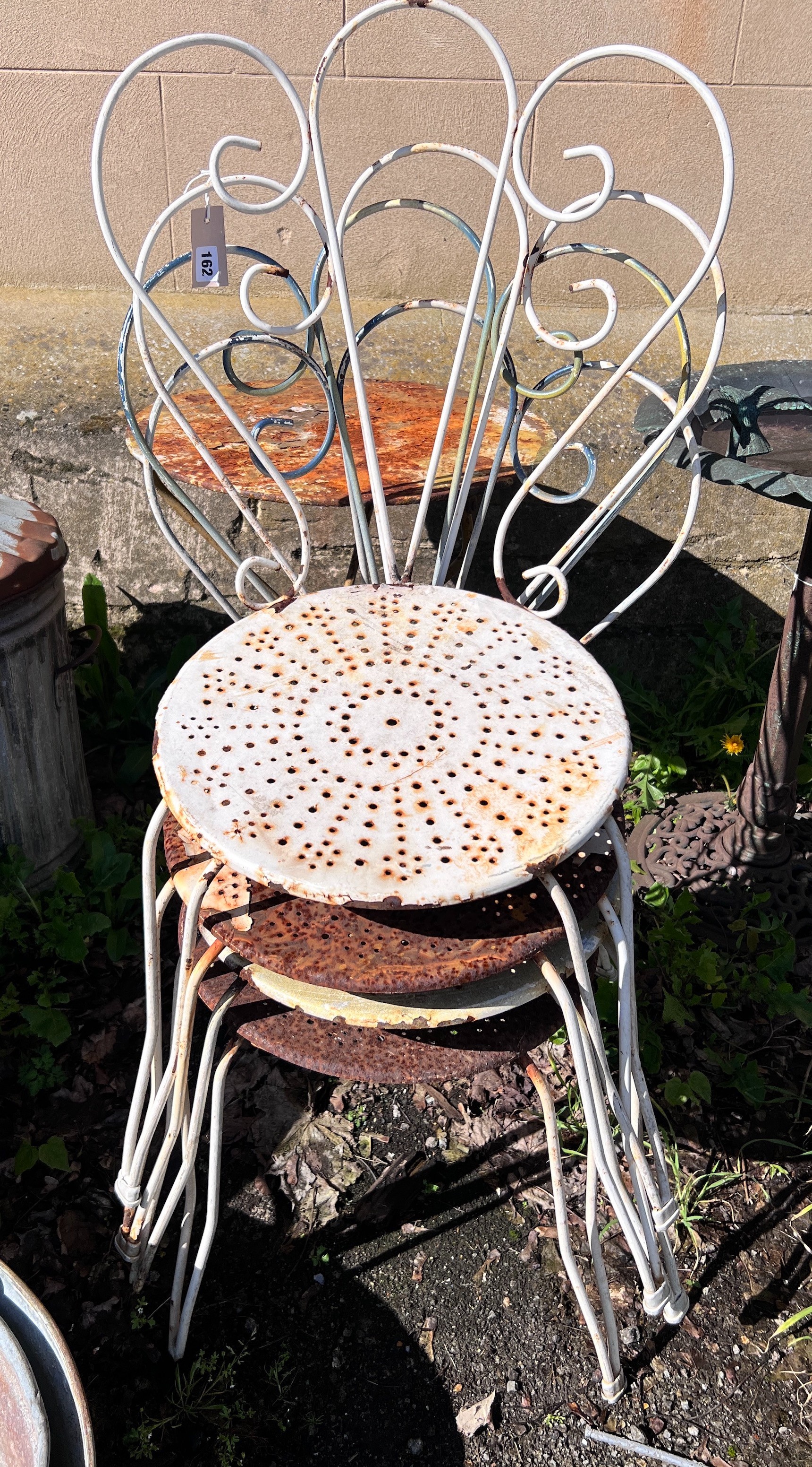 A circular wrought iron garden table and four chairs, diameter 50cm, height 80cm *Please note the sale commences at 9am.